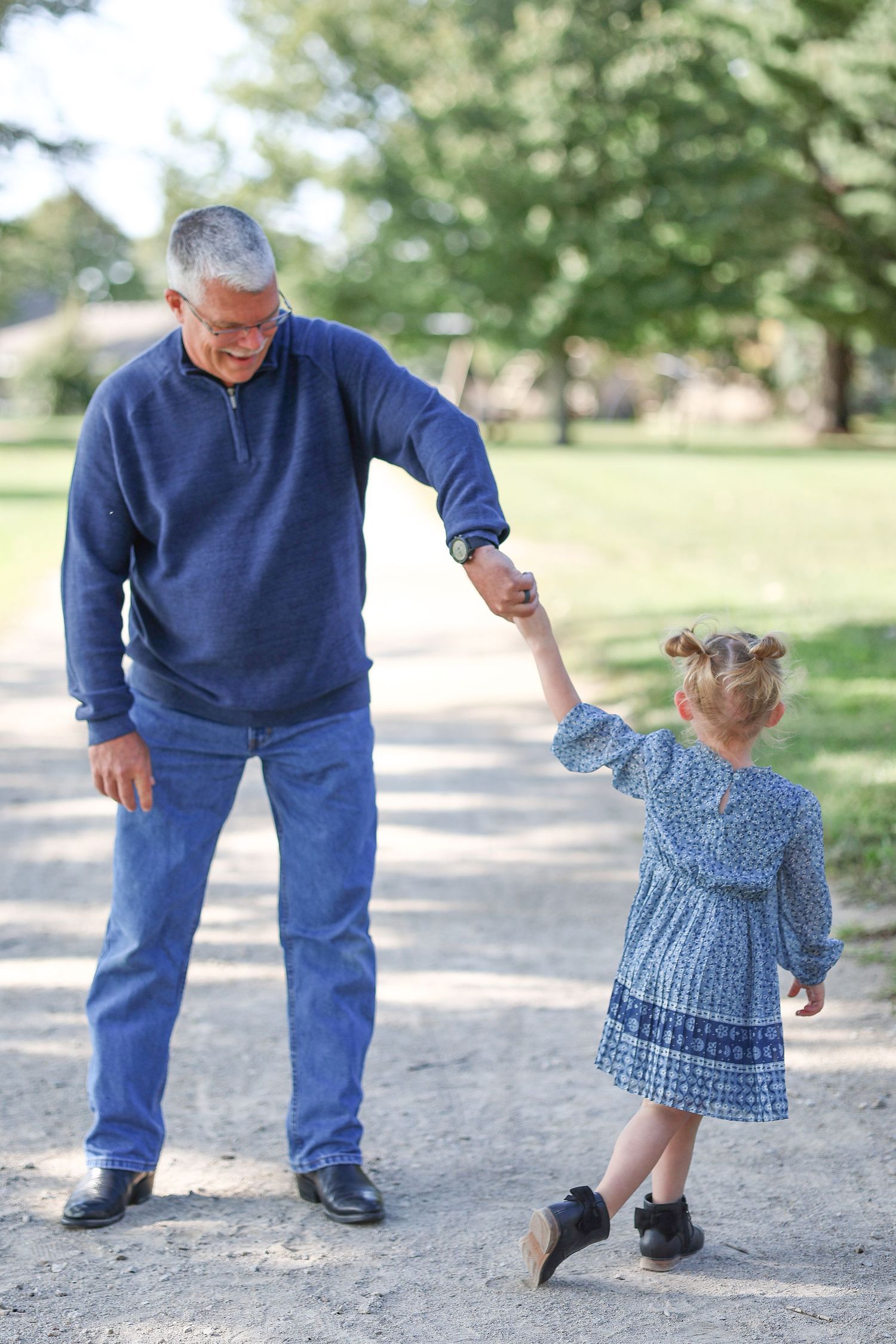 Springfield, IL family photographer captures a grandpa spinning his granddaughter during a photo session in Central, IL