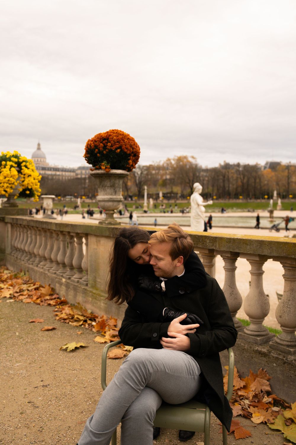 A romantic autumn scene in Luxembourg Gardens, Paris with fallen leaves and ornate stone balustrade in soft lighting.
