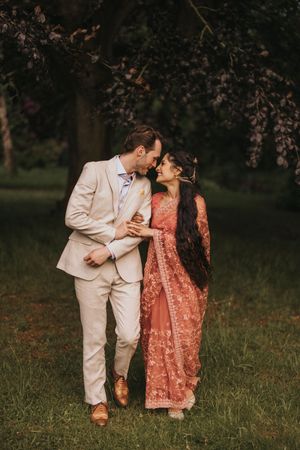 Couple sharing romantic moments in a grassy outdoor setting. Captured by Lincolnshire photographers.