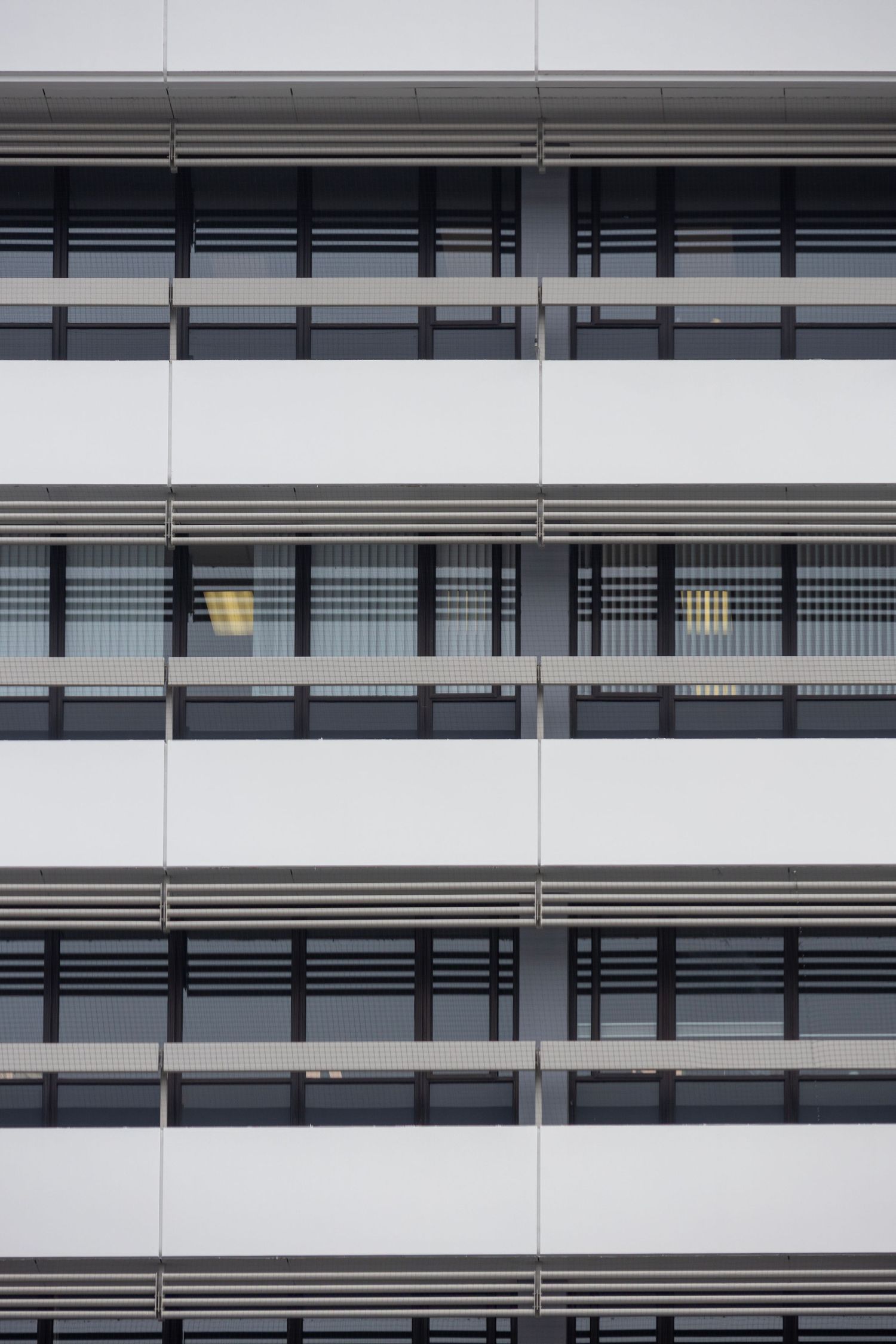 Repetitive black and white window façade with strong horizontal lines and a clean, minimalist architectural look.