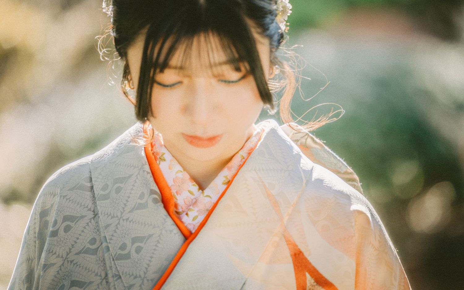 Traditional Asian garment with orange collar and sleeves surrounded by soft blurred foliage in background.