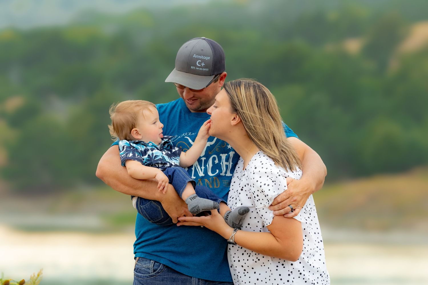 A family shares joyful moments together in a natural outdoor setting by a lake.