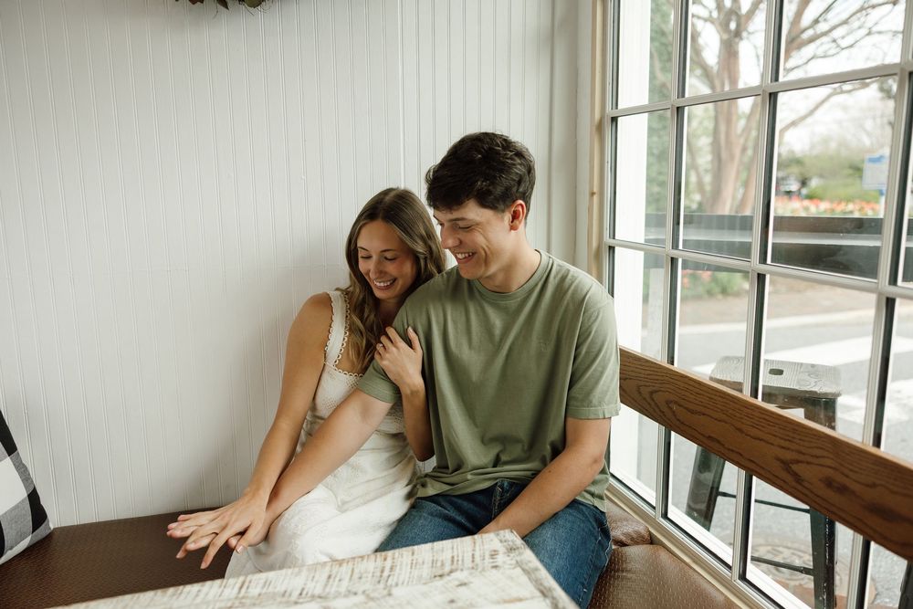 Intimate couple photoshoot in a bright indoor setting with white walls.