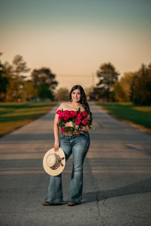 A series of sunset portraits on a rural road featuring a red floral top, cowboy hat, and denim jeans.
