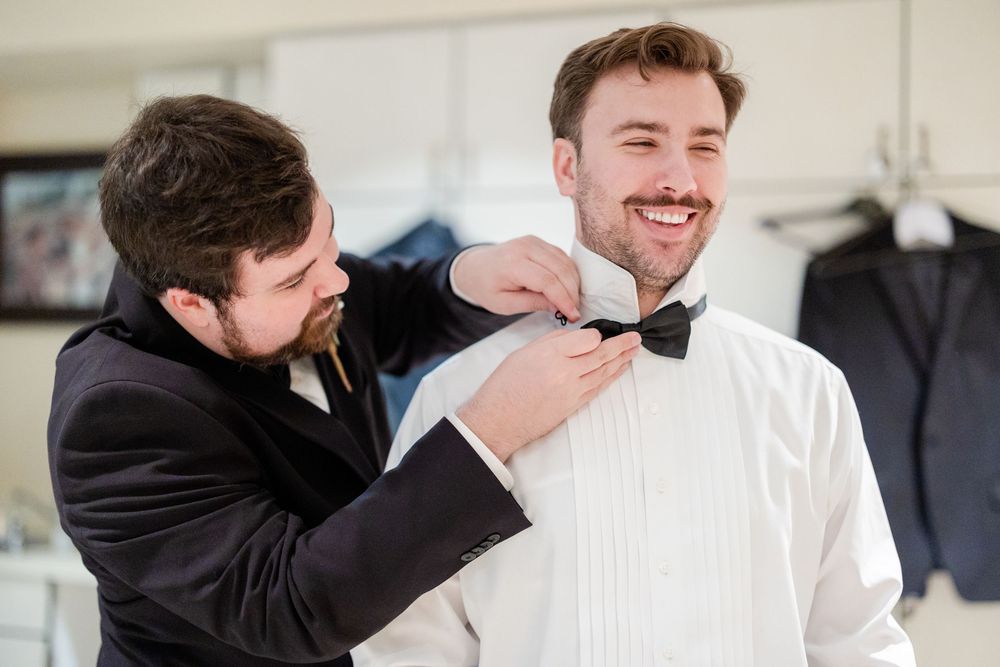 Wedding couple shares playful candid moments in formal attire during their celebration.