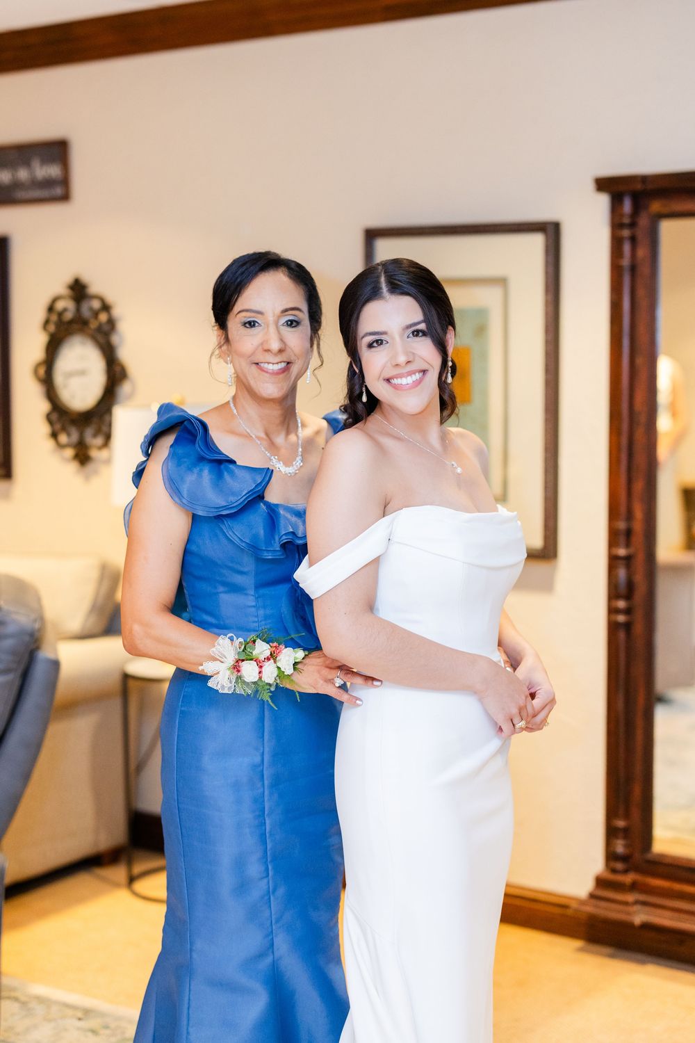 Wedding party members in elegant blue and white dresses pose together in preparation for the ceremony.