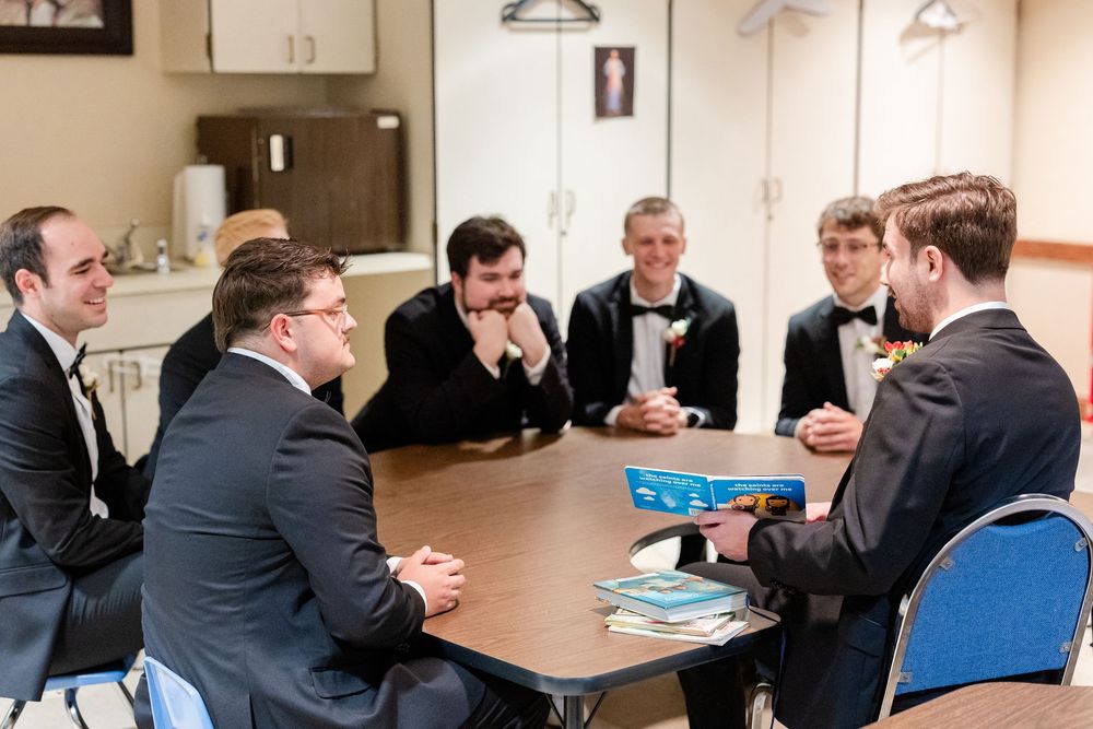 A group of men in suits sit around a conference table having a discussion.