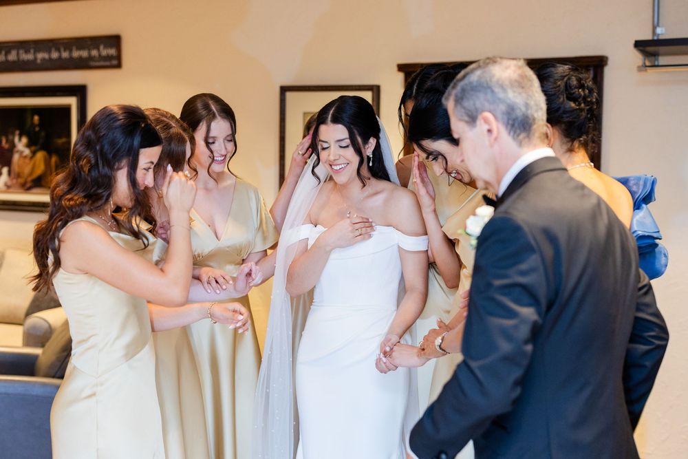 Wedding party gathered indoors as they prepare for the ceremony in formal attire.