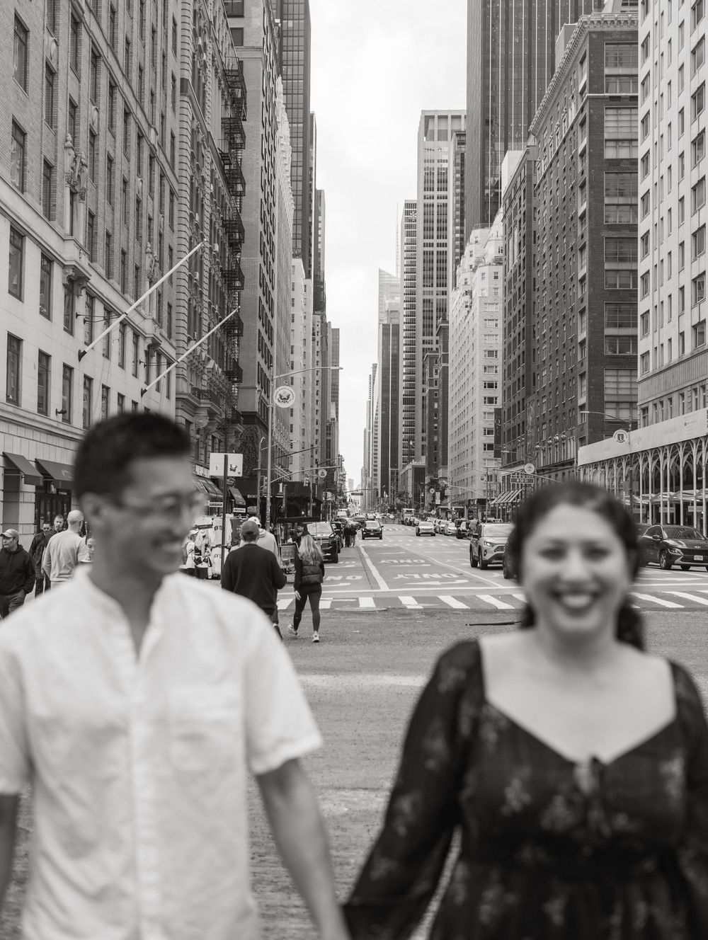 Black and white photo of people walking on a city street lined with tall buildings in Chicago.