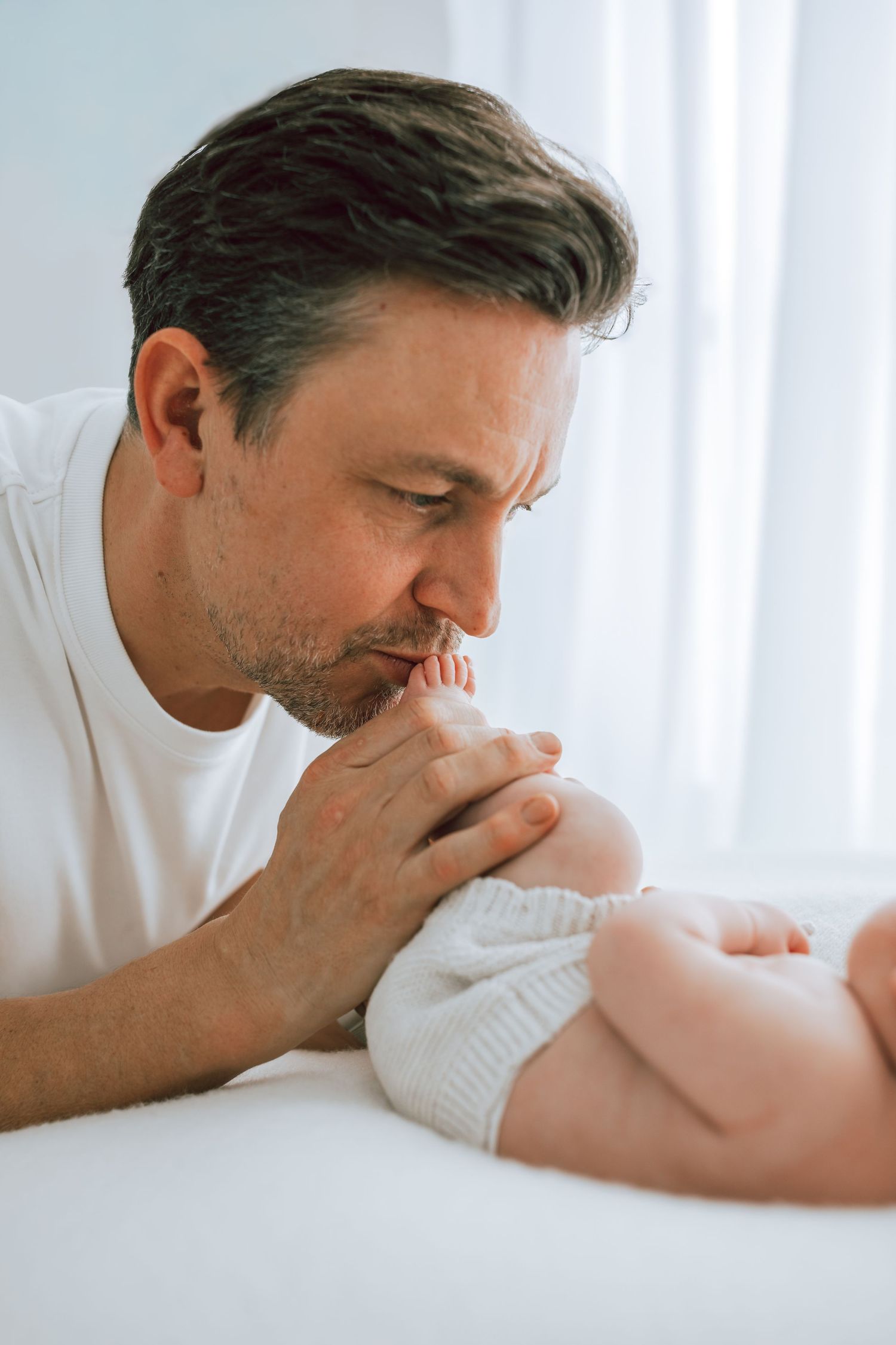 Father kissing baby's feet
