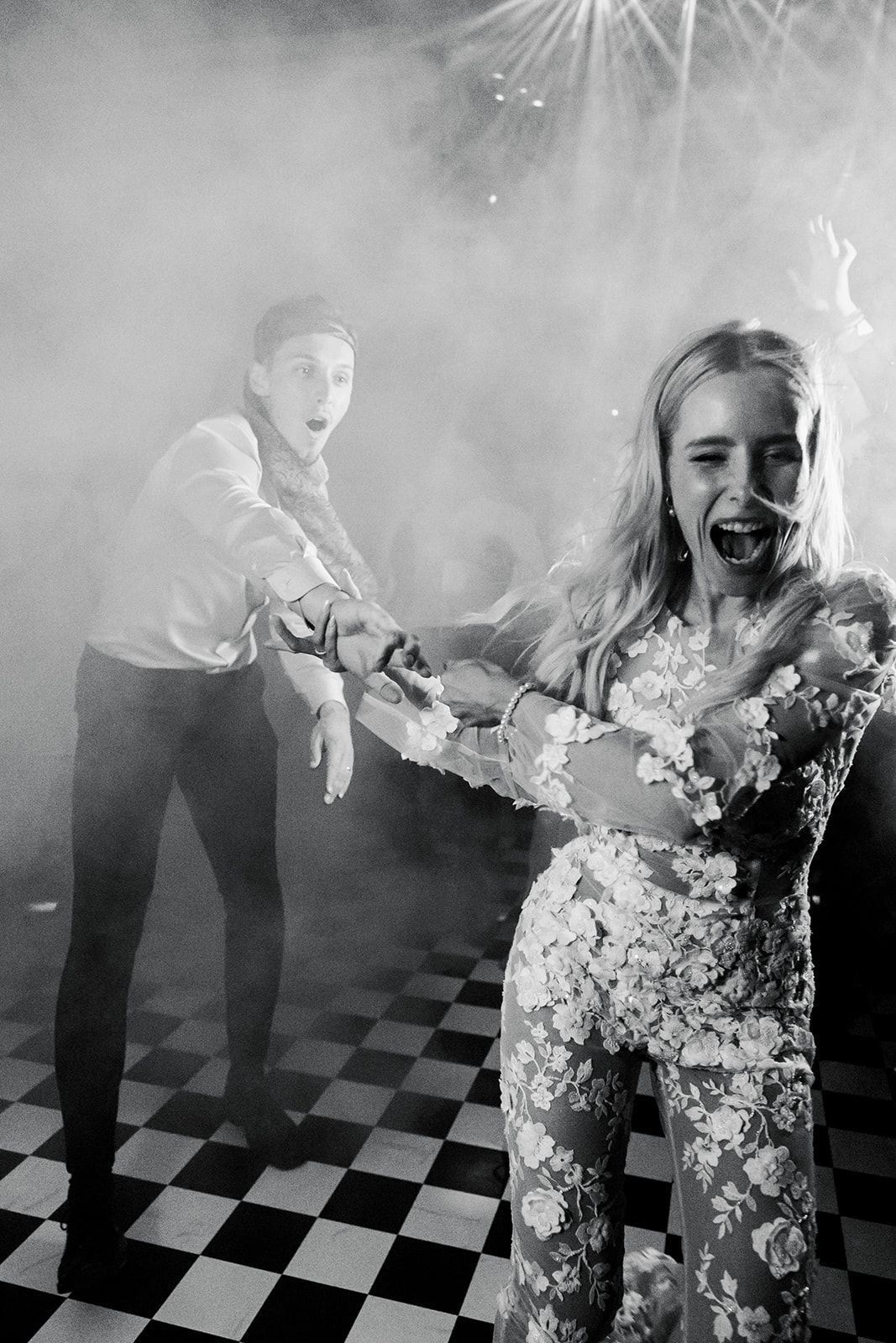 A sequence of black and white photos showing someone playing with smoke effects on a checkered floor.