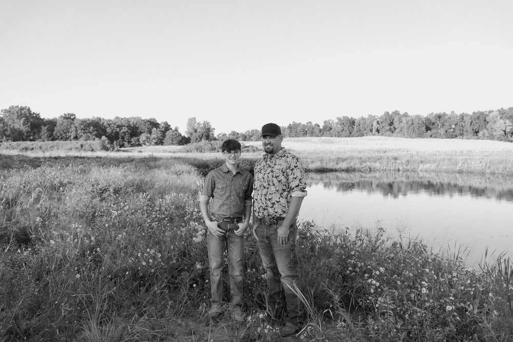 A series of black and white landscape photographs showing fields, lakes and rural scenes in a panoramic format.