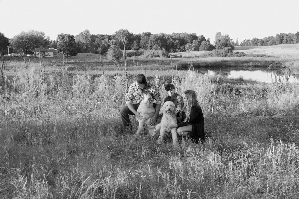 A black and white panoramic sequence showing people walking through a grassy field on a sunny day.