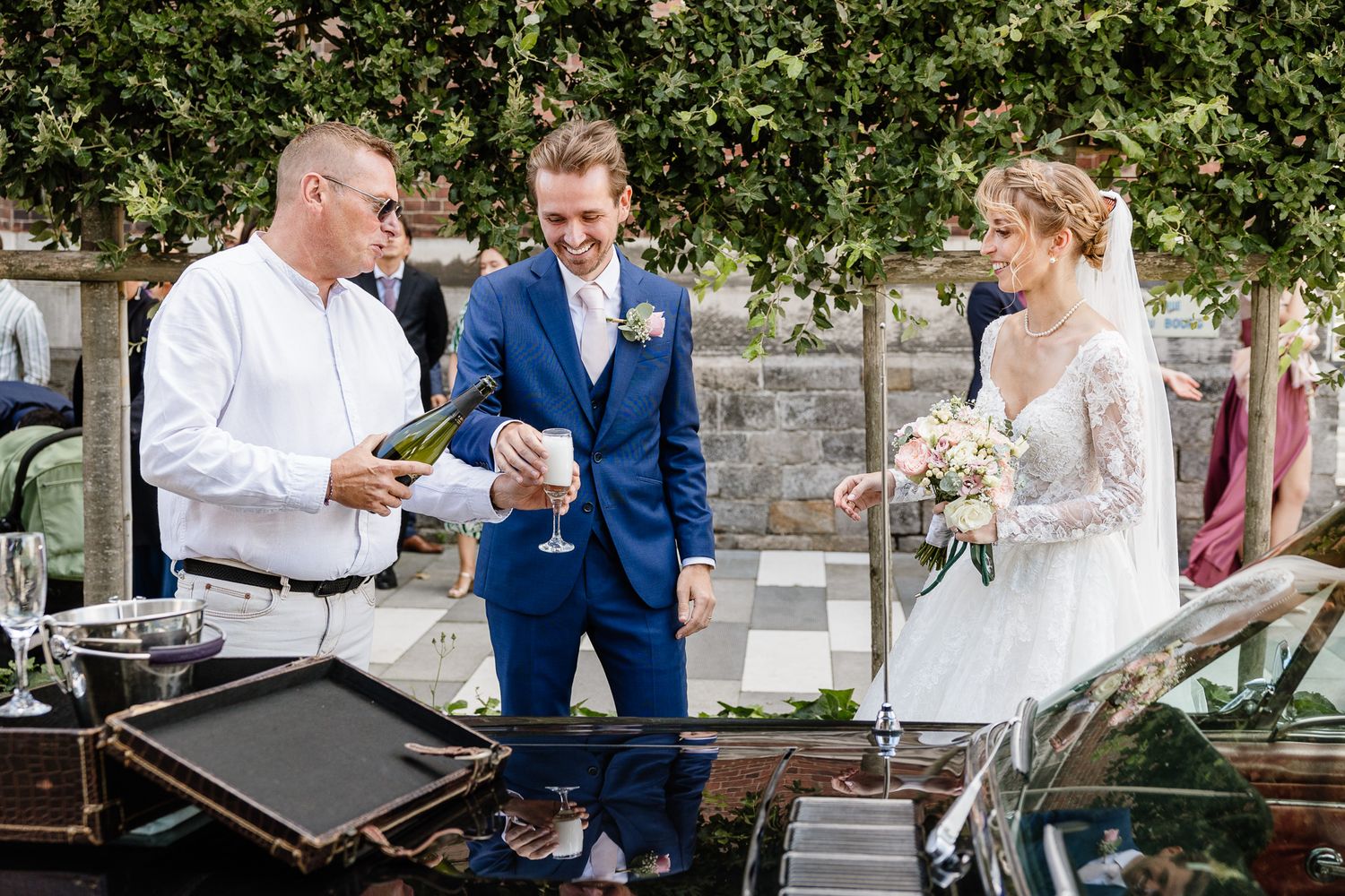 Reportage photo mariage Lille : les maries trinquent au champagne en sortant de l'eglise de lambersart