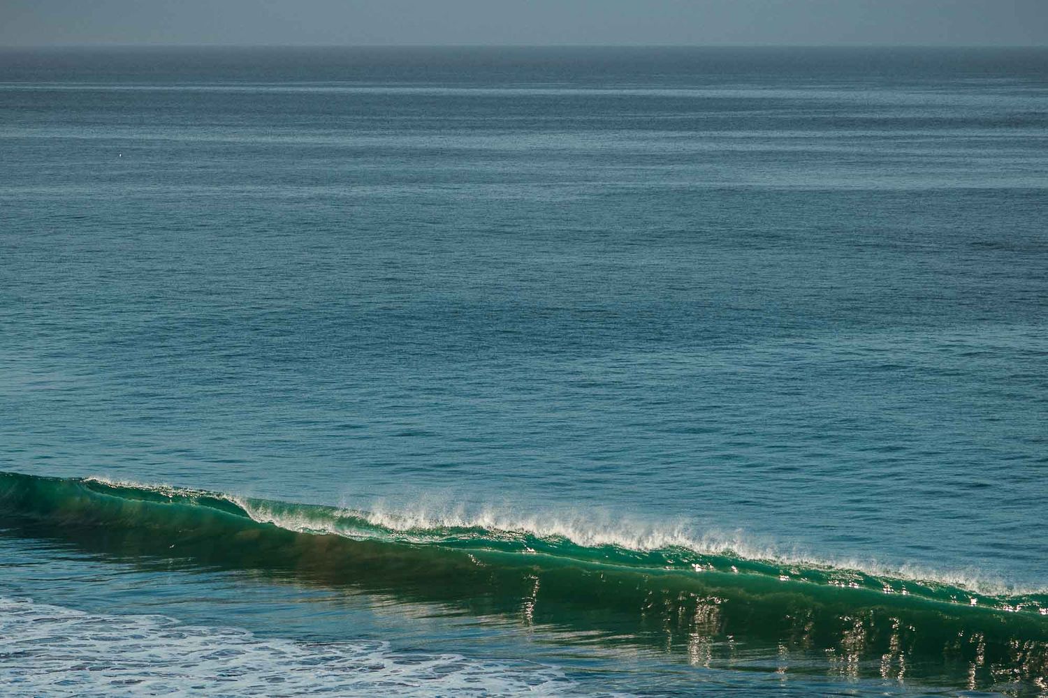 Crystal clear turquoise waves forming perfect curls in the ocean.