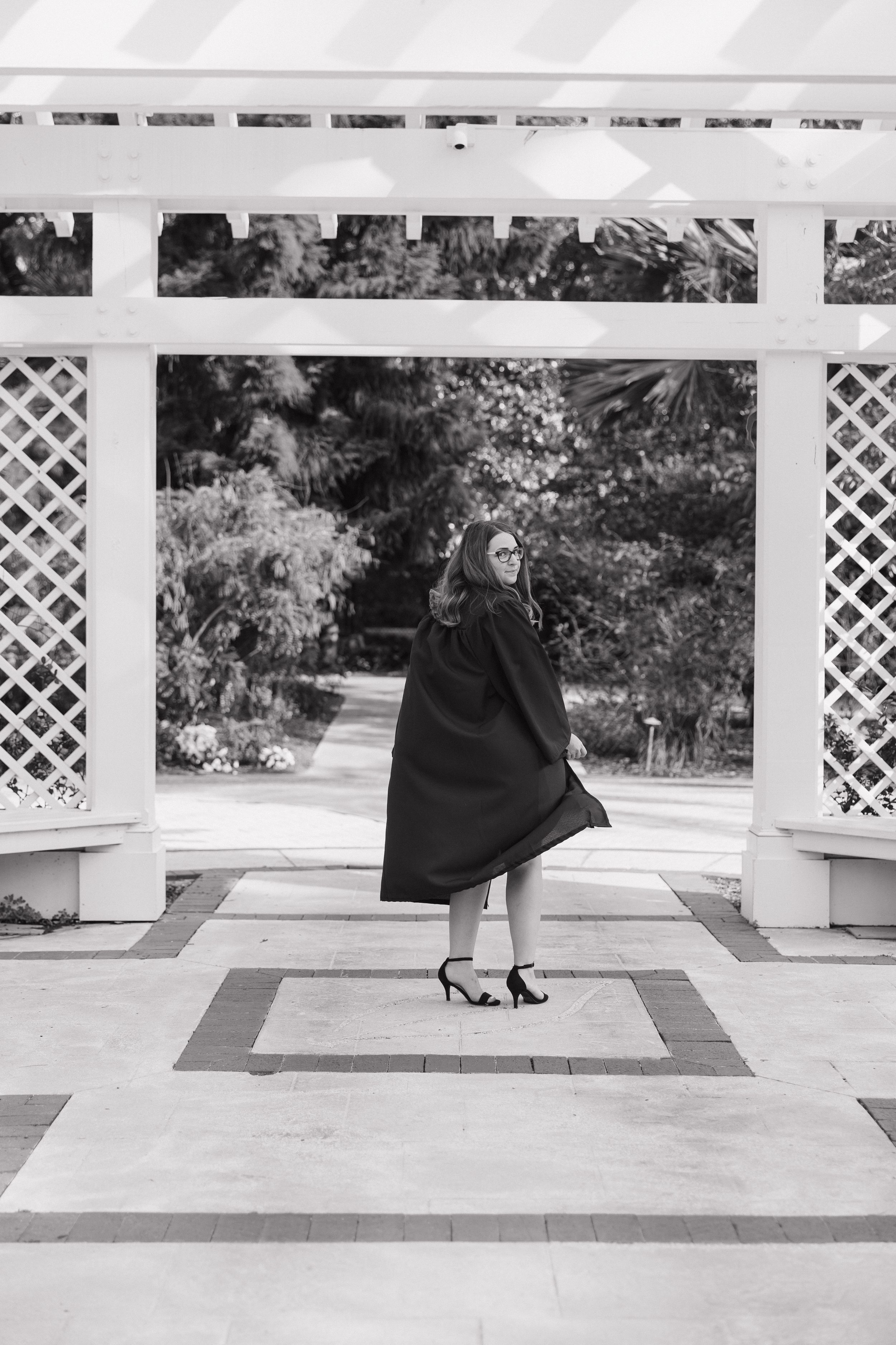 Black and white photo of figure walking on geometric patterned patio.
