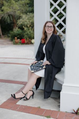 Portrait session against white lattice wall with brick pathway.