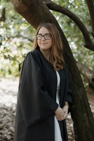 Professional portrait under tree branches in natural setting.
