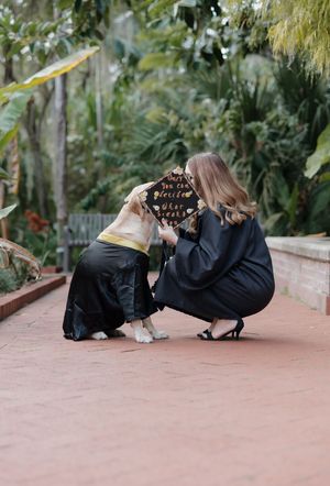 Two photographers lying on a brick pathway taking creative photos in a tropical garden setting.