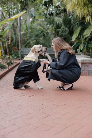 Photographers in black outfits taking low-angle shots on a brick pathway with a dog in the background.