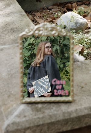 Someone holding a chalkboard sign against a leafy green background through a concrete frame.