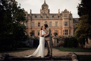 A grand historic mansion serves as an elegant wedding venue backdrop.