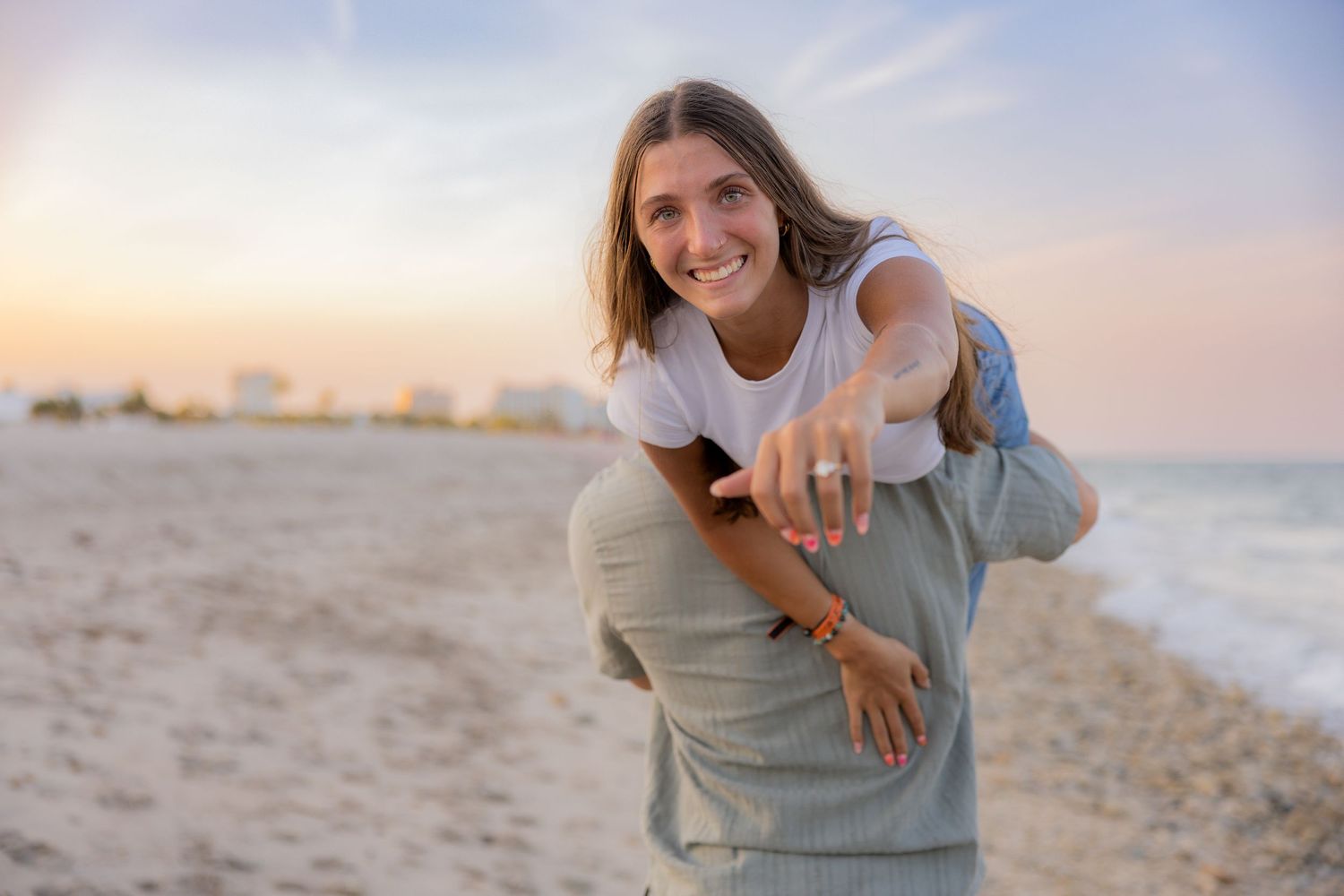 Bride over fiancé's shoulder showing off ring at beach in Fort Lauderdale