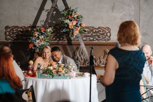 A panoramic view of a wedding reception venue decorated with floral arrangements and elegant table settings.