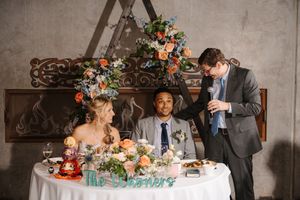 Wedding couple shares intimate moments during their reception in a rustic venue with floral decorations.