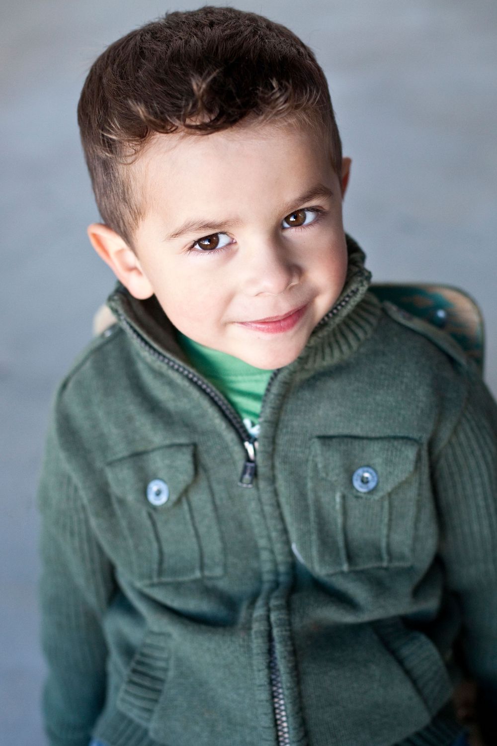 portrait of a young boy wearing a green jacket