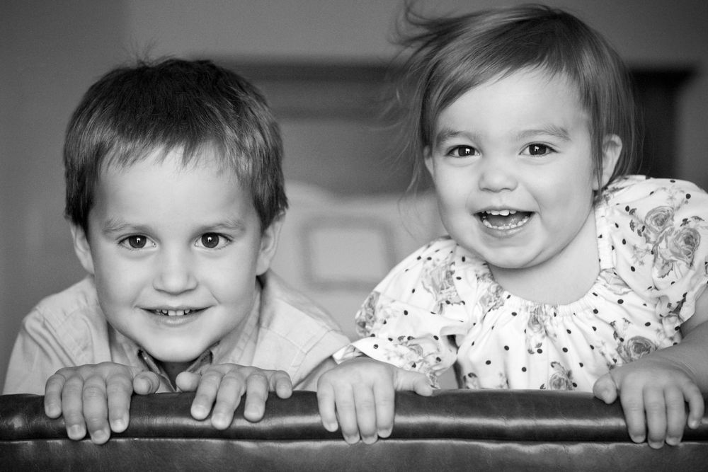 Black and white portrait of a brother and sister smiling