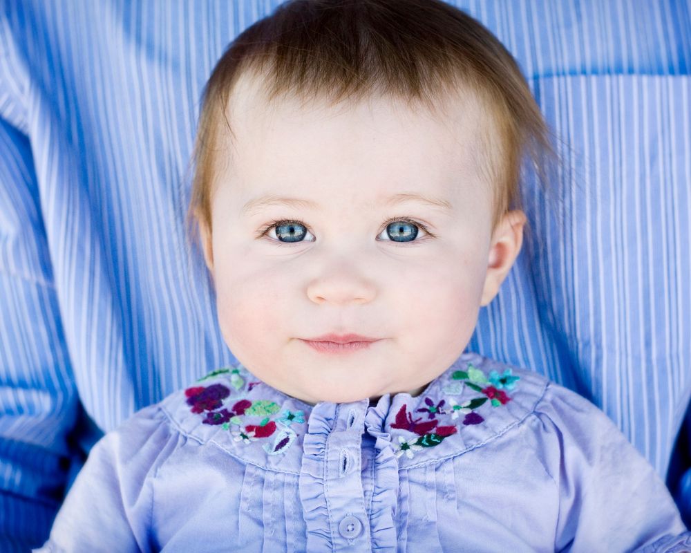 image of a smiling baby with blue eyes and a blue background