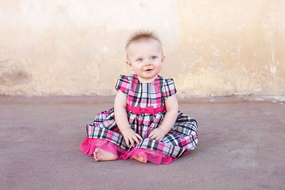 Smiling baby in pink plaid dress