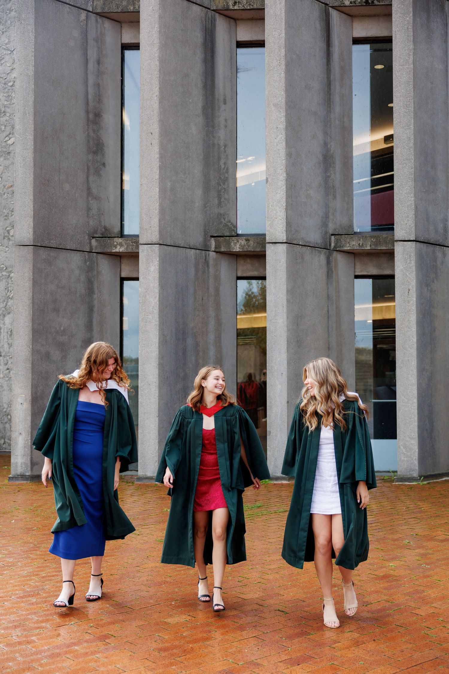 A series of four photos showing graduates in green gowns walking between concrete columns at a graduation ceremony.