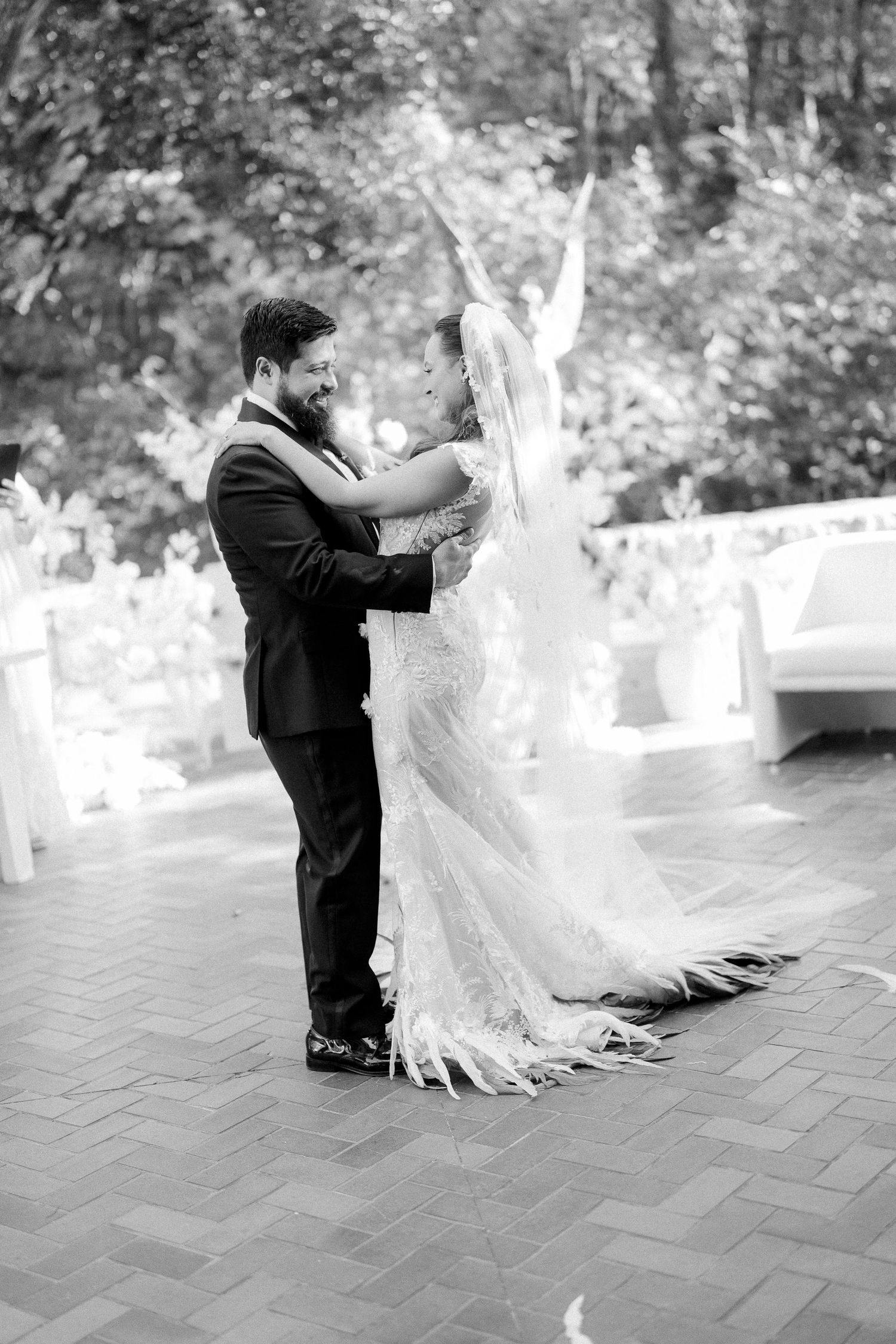 Black and white editorial wedding photo series capturing a couple dancing together on a brick patio during a romantic destination wedding