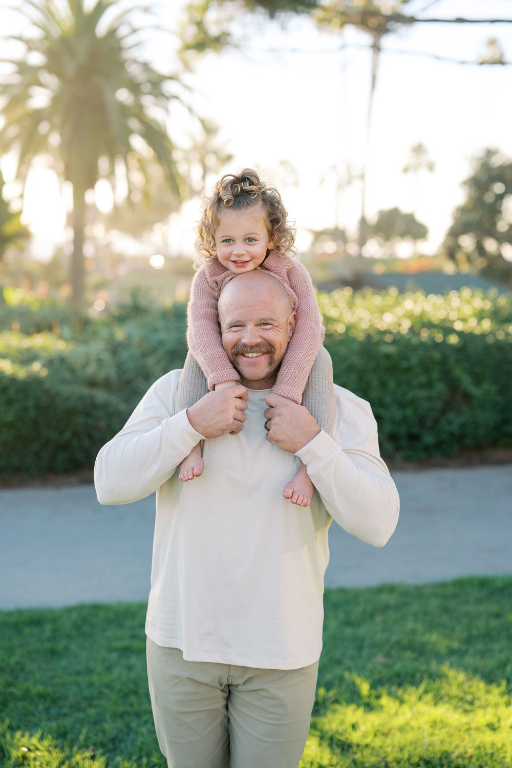 A series of playful outdoor family portraits showing joyful interactions between parent and child on a sunny day.