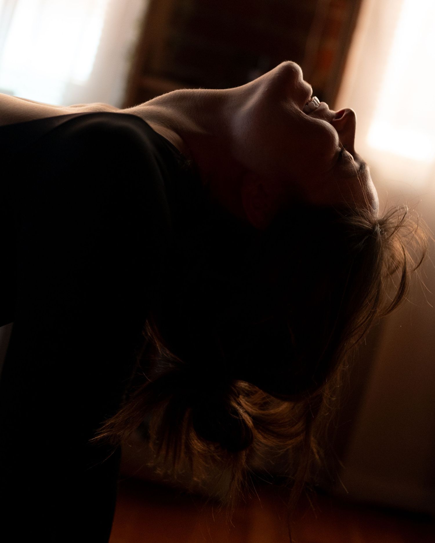 A silhouetted profile of a person against a warm backlit glow creating a dramatic and moody atmosphere.
