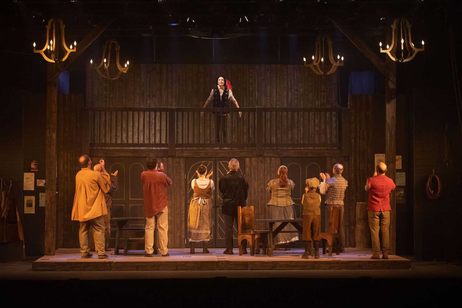 Theater performance on stage with dramatic lighting and multiple actors.