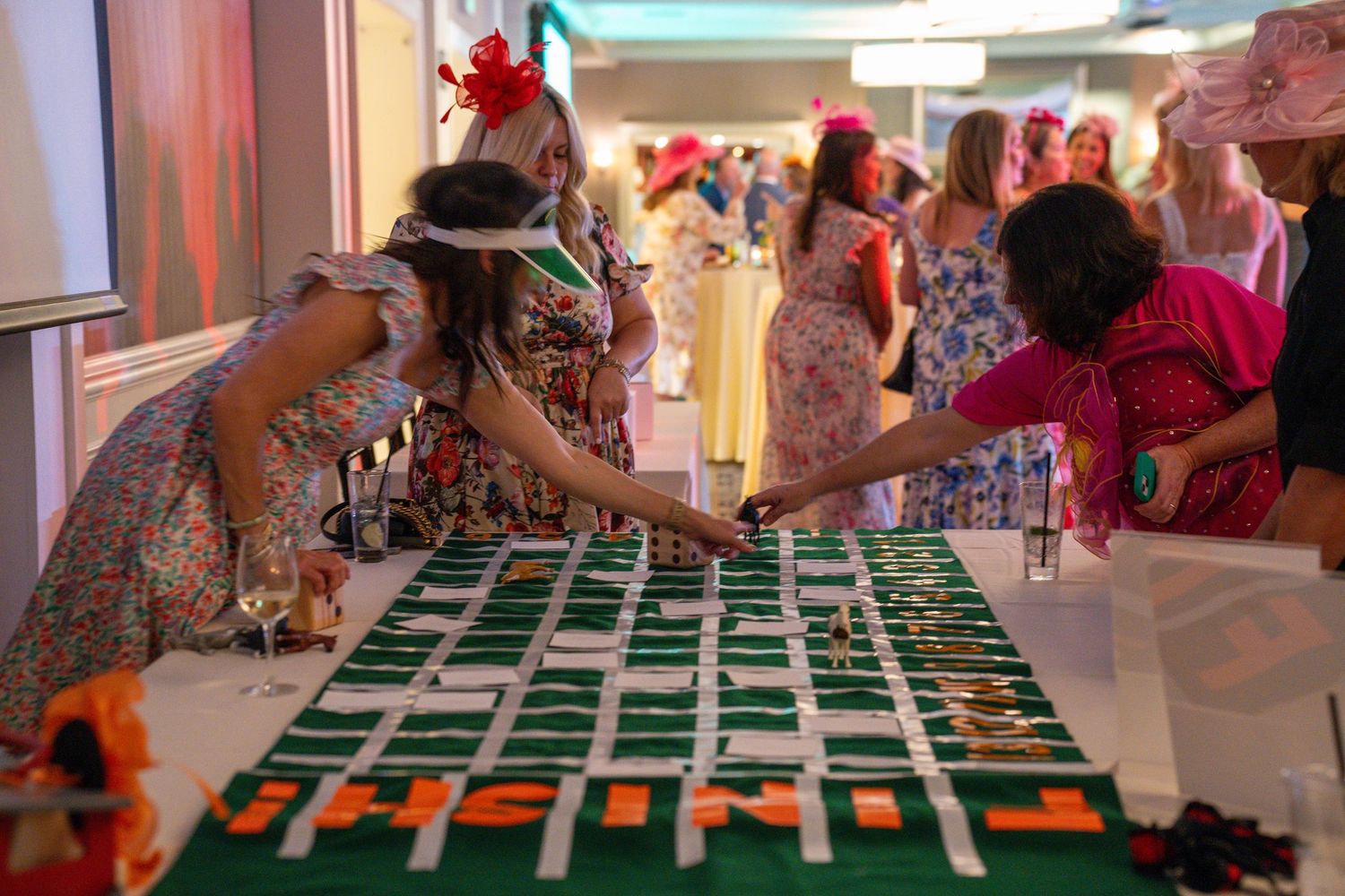 Green felt casino gaming tables set up for a private event with decorative lighting.