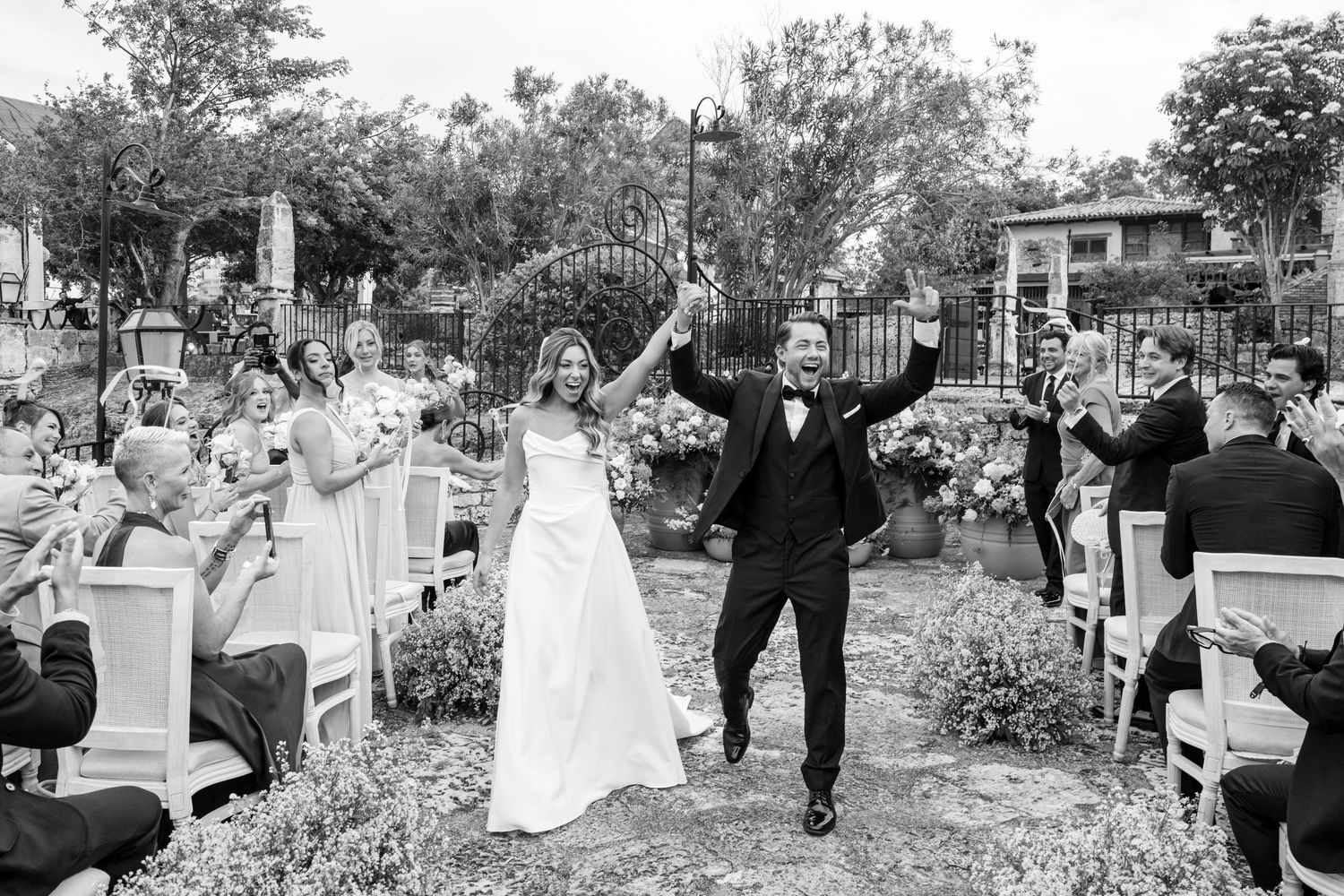 A series of black and white wedding photographs showing joyful moments during an outdoor garden ceremony and celebration.