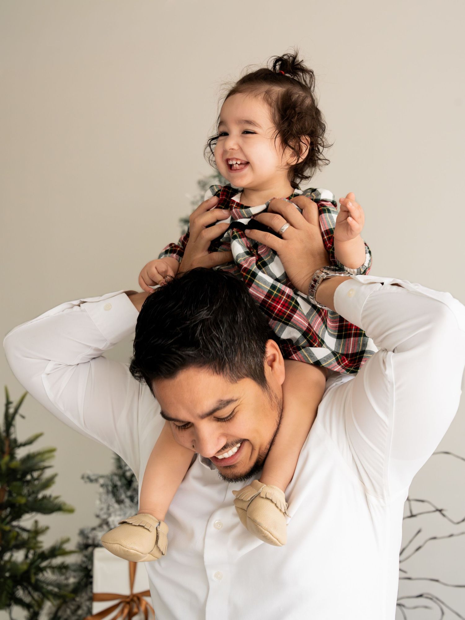 Joyful moments captured in a white studio as a parent and child play together.