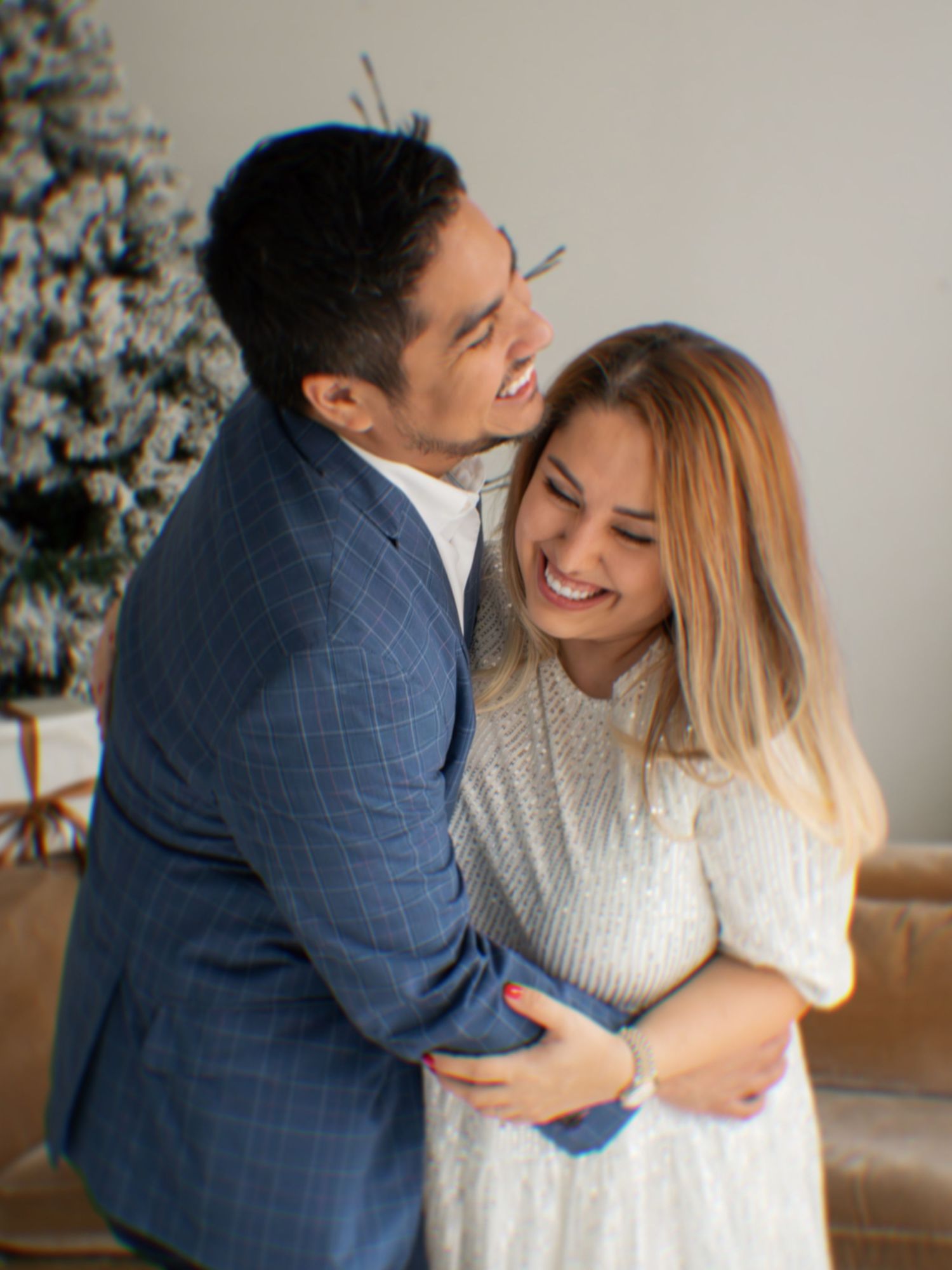 Couple sharing intimate moments on couch with Christmas tree in background, shown in progressive candid shots.