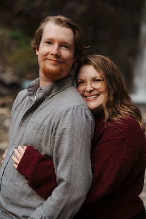 A couple in a gray sweater and burgundy sweater share intimate moments in a series of romantic outdoor portraits.