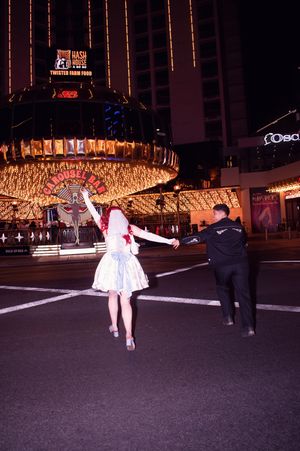 Brides running across Fremont Street towards the carousel bar