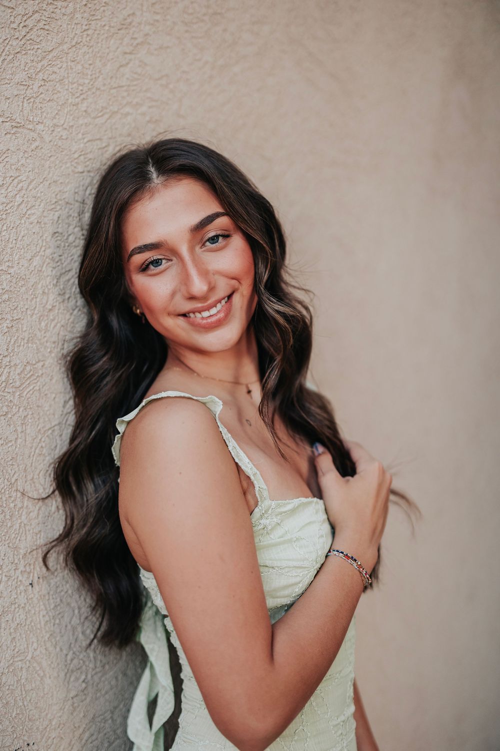 Close-up shots showing a mint green dress with delicate straps against a neutral wall.