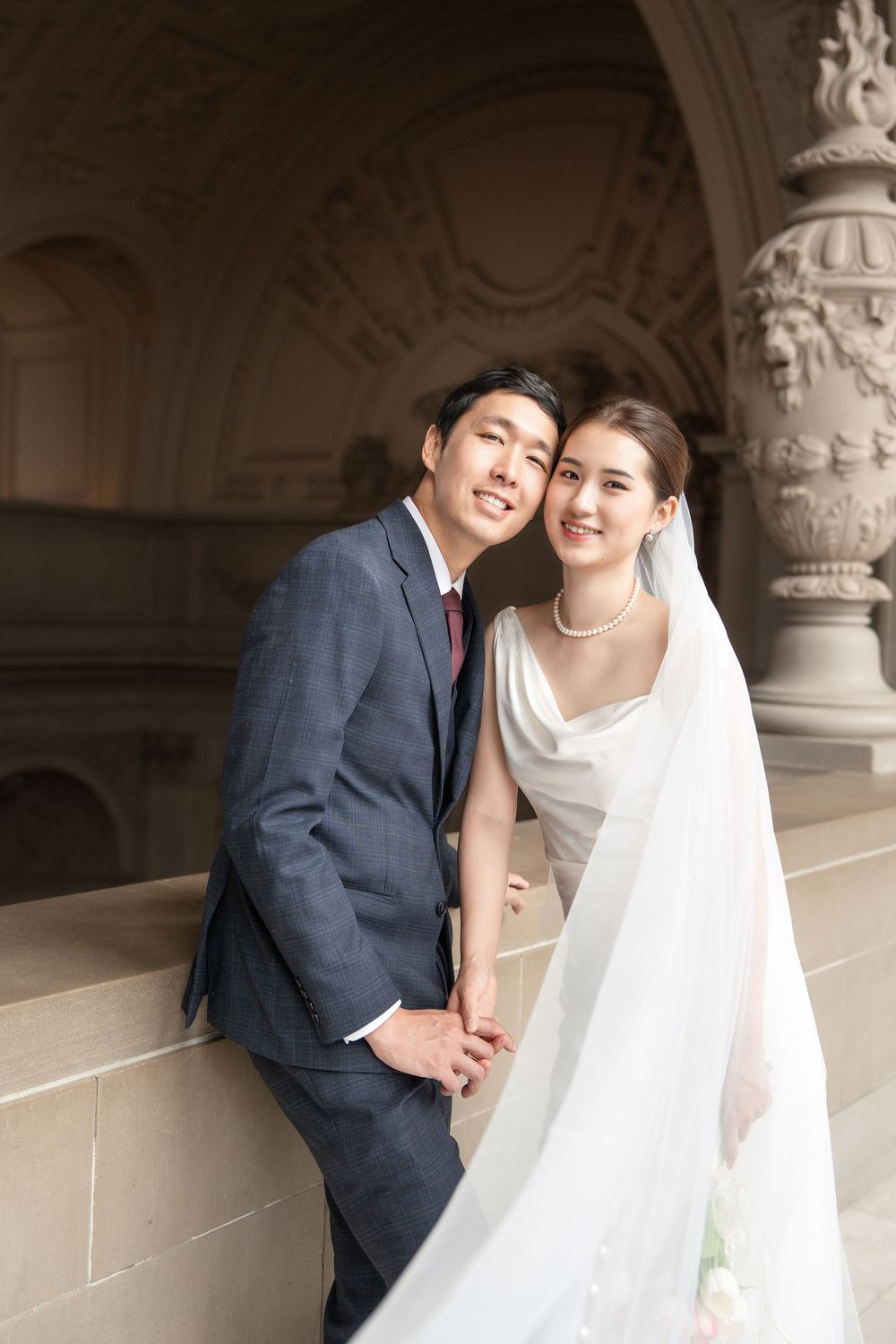 Candid wedding portraits capturing intimate moments between newlyweds in an ornate marble corridor.