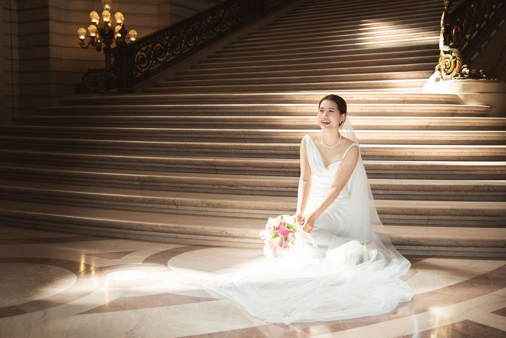 Elegant chandelier illuminates grand staircase in warm lighting creating dramatic architectural ambiance.