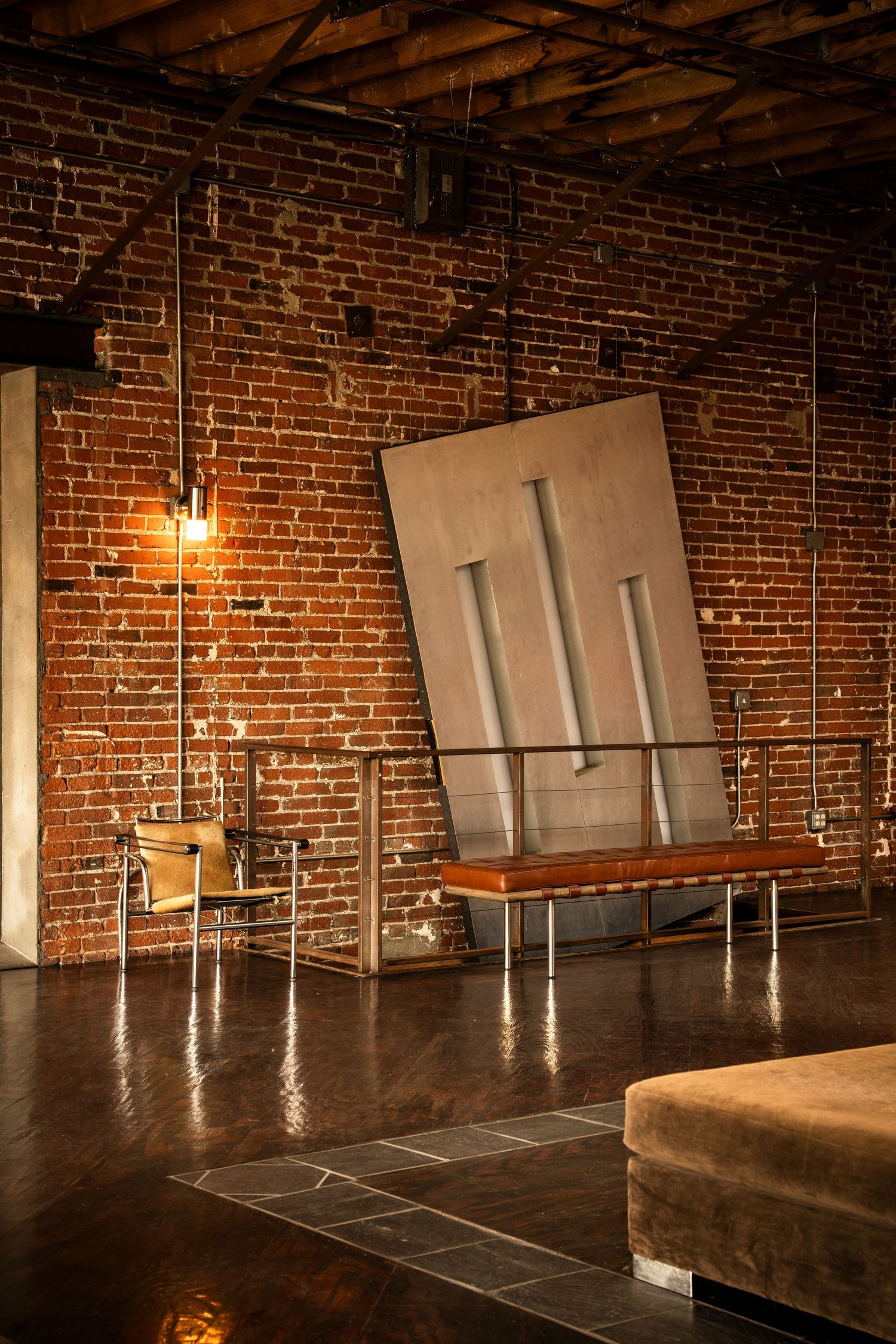 Modern dance studio interior with exposed brick walls, hardwood floors, and large mirrors for practice sessions.