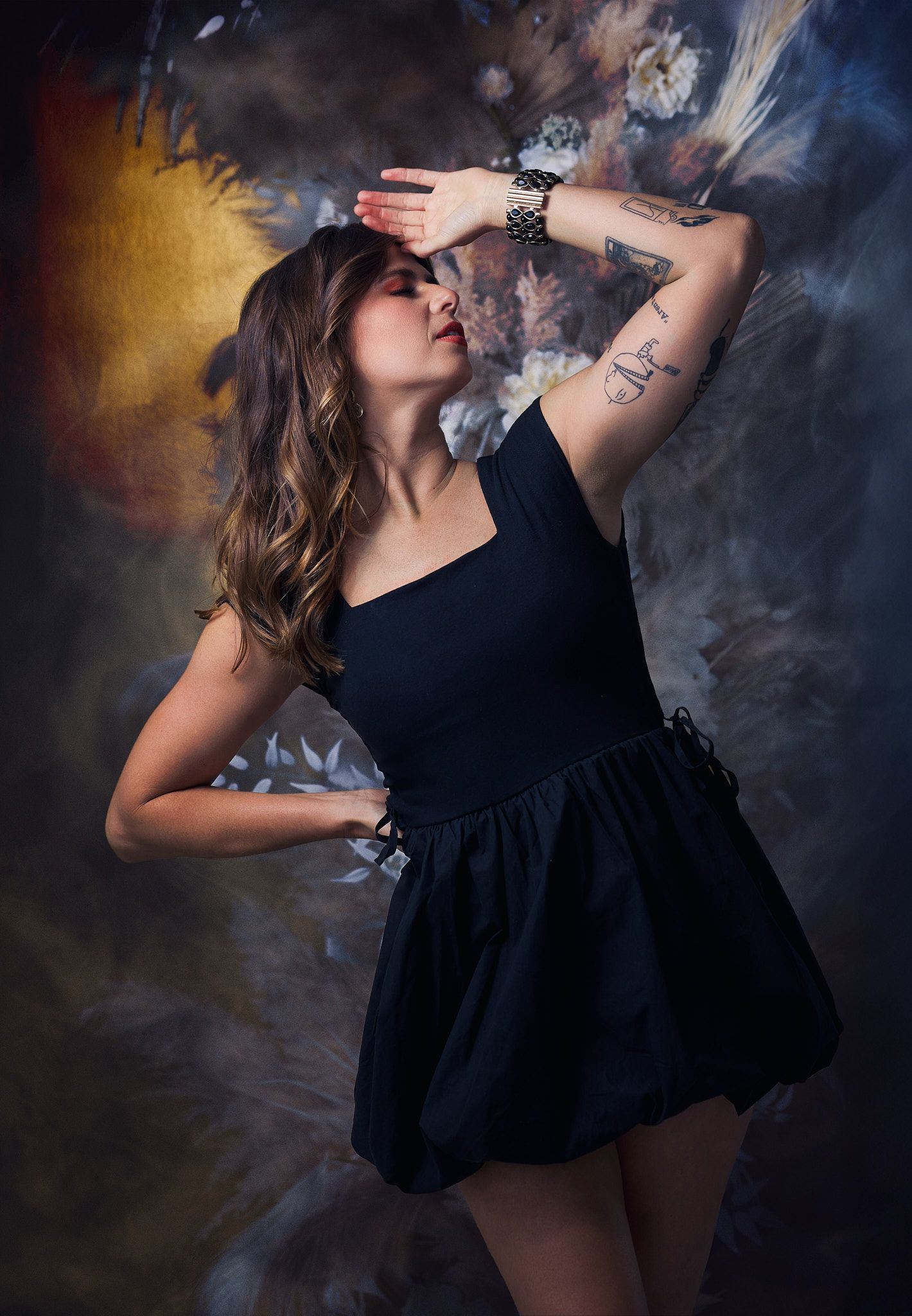 Dramatic fashion portraits in black dress against smoky background with artistic lighting effects.