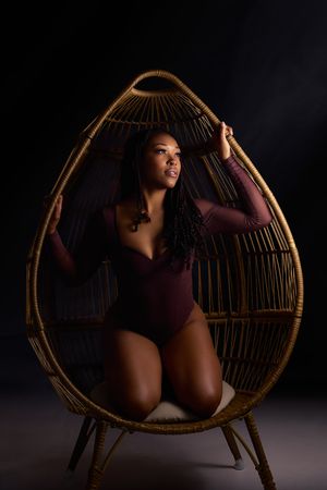 Artistic photo series showing dramatic poses on a vintage rattan chair against dark background.
